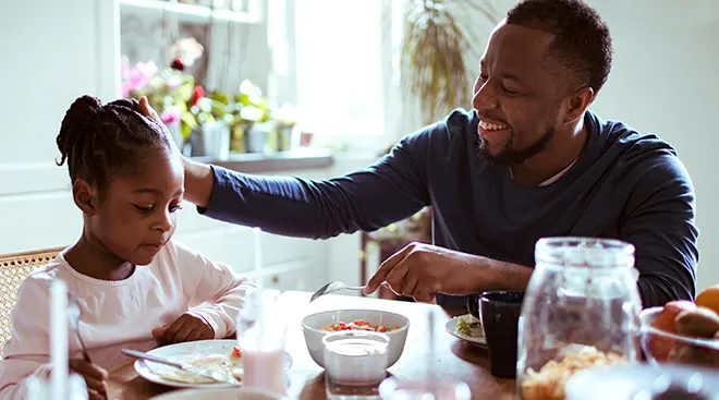 dad having meaningful conversation with his daughter in the kitchen during breakfast