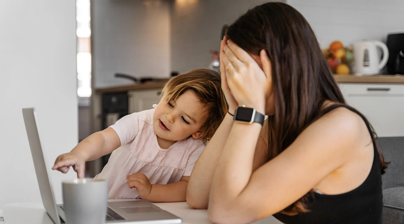 annoyed mother sitting at table with toddler