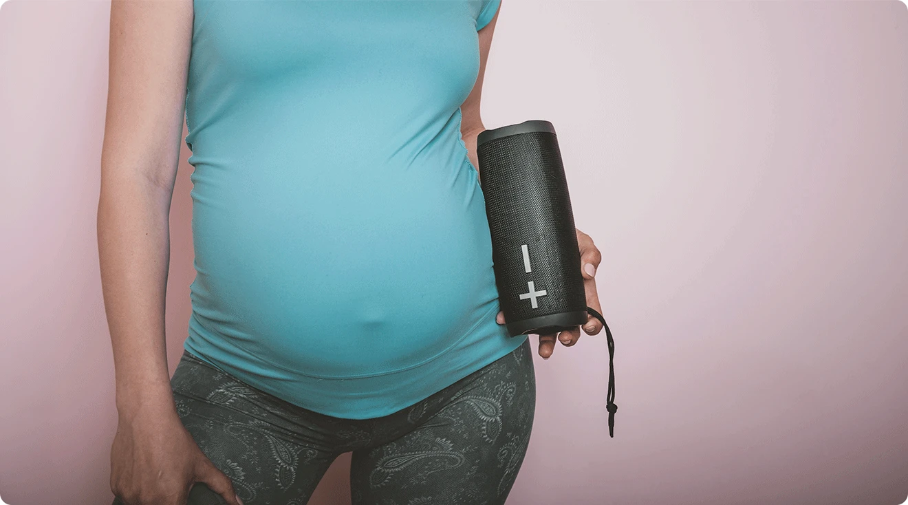 pregnant woman holding a music speaker