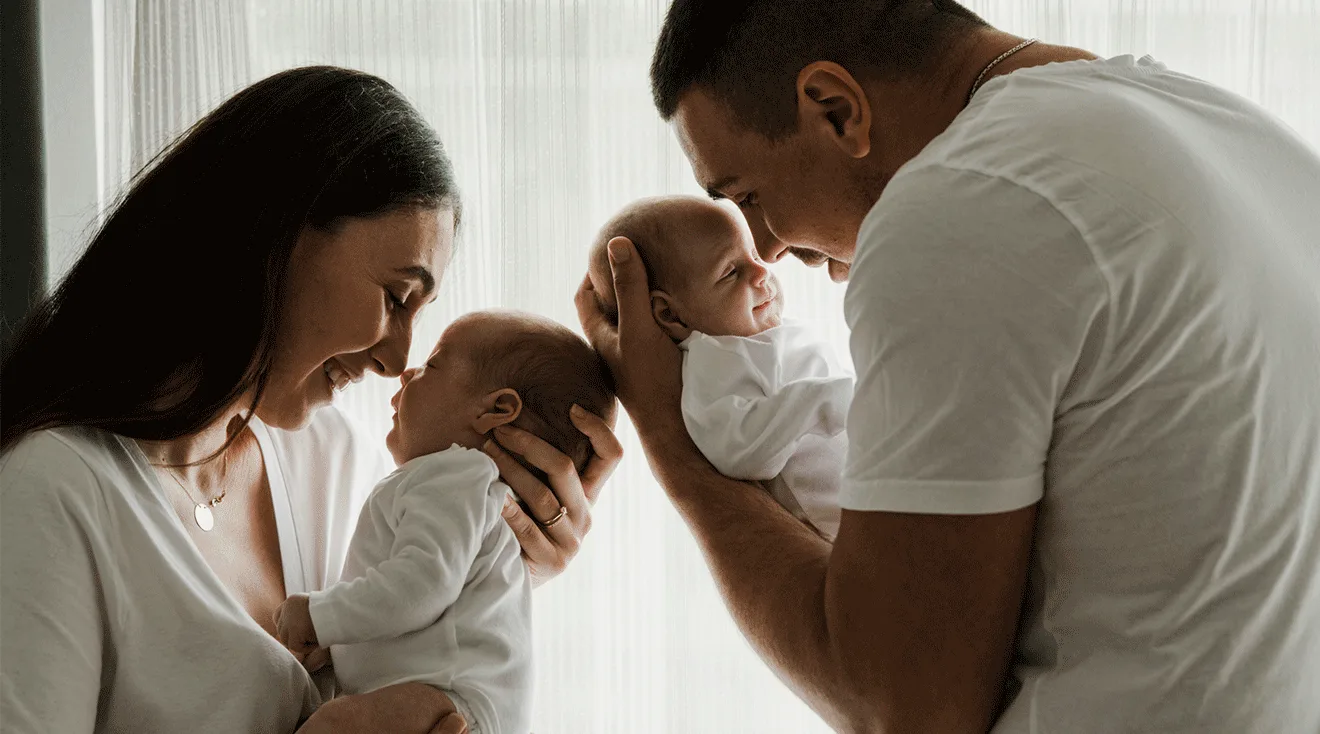 mom and dad holding their twin babies