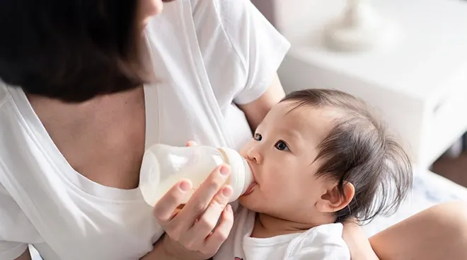 mother giving baby a bottle