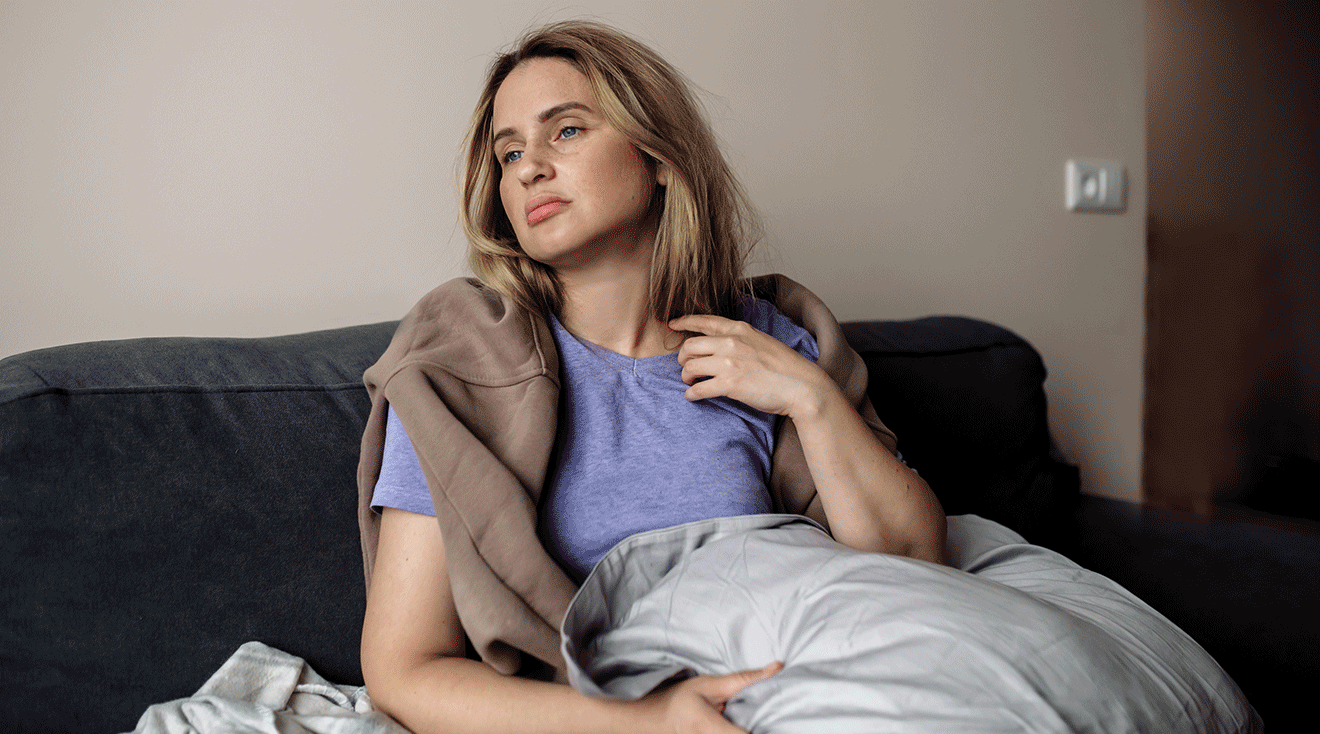 young woman sick on the couch at home
