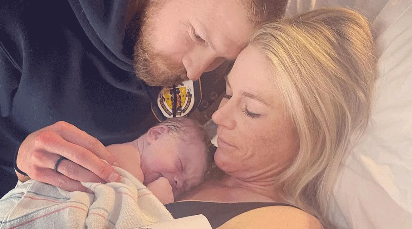 kellyn taylor holding newborn baby with husband