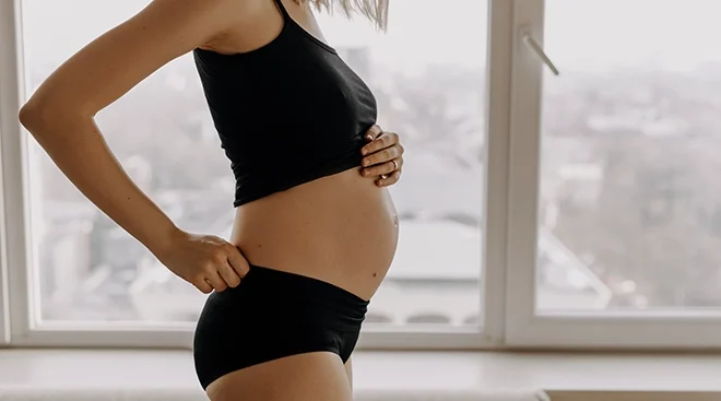 pregnant woman with small baby bump at home