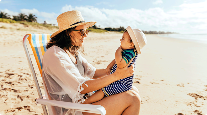 mom and baby at the beach on a sunny day during summertime