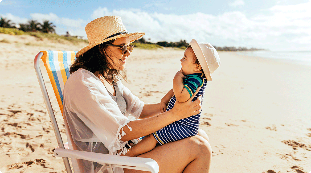 mom and baby at the beach on a sunny day during summertime
