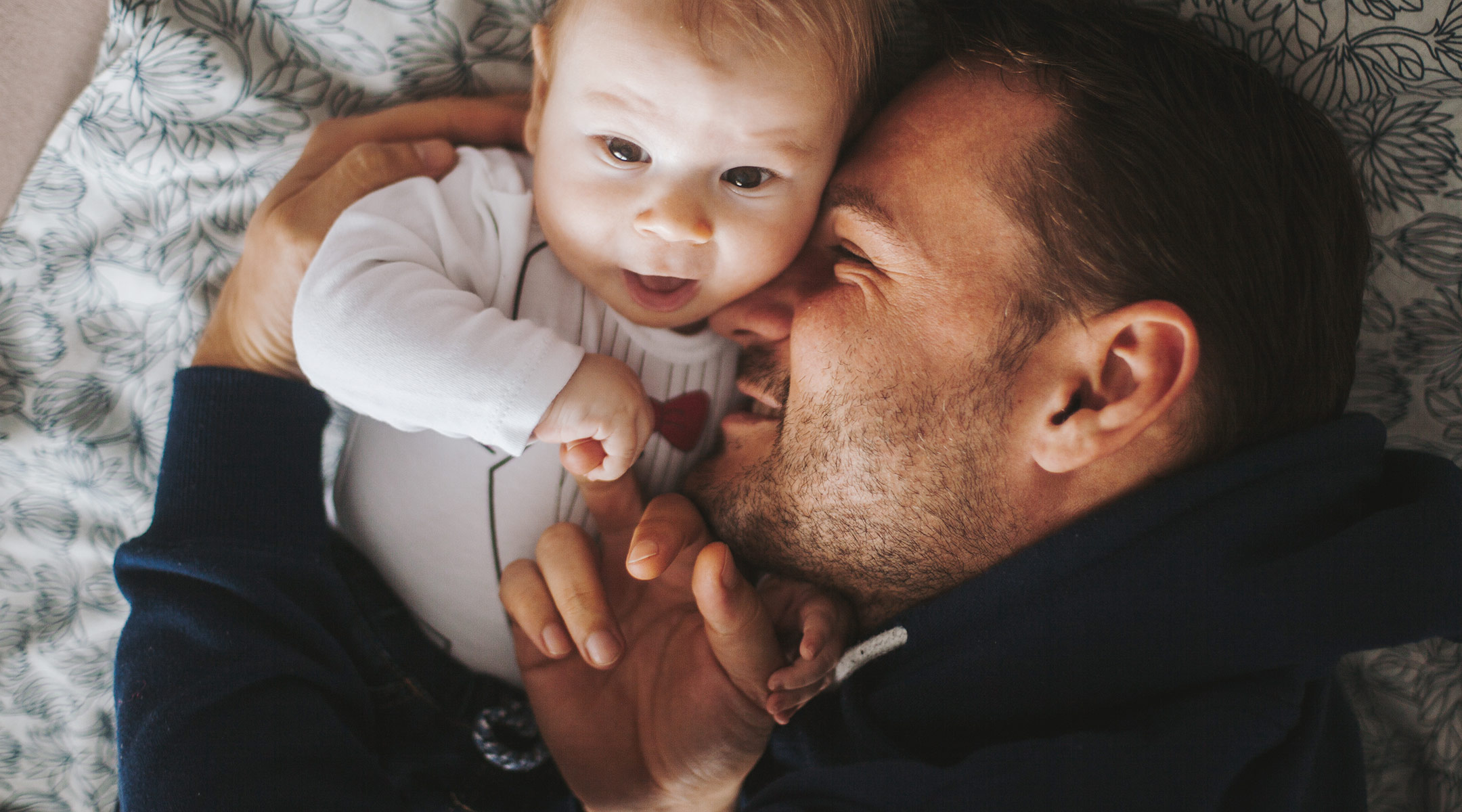 dad cuddling with new baby