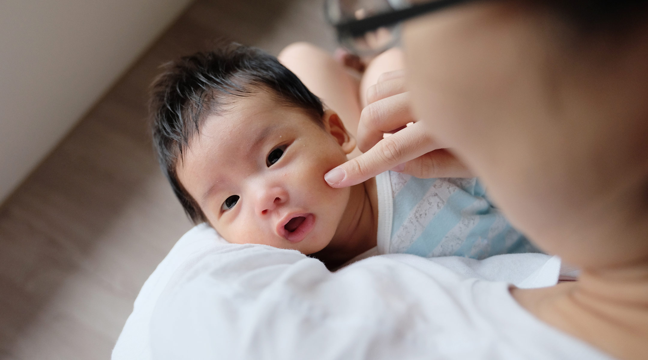 newborn baby looking up and being held