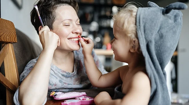 mother and daughter playing with makeup at home