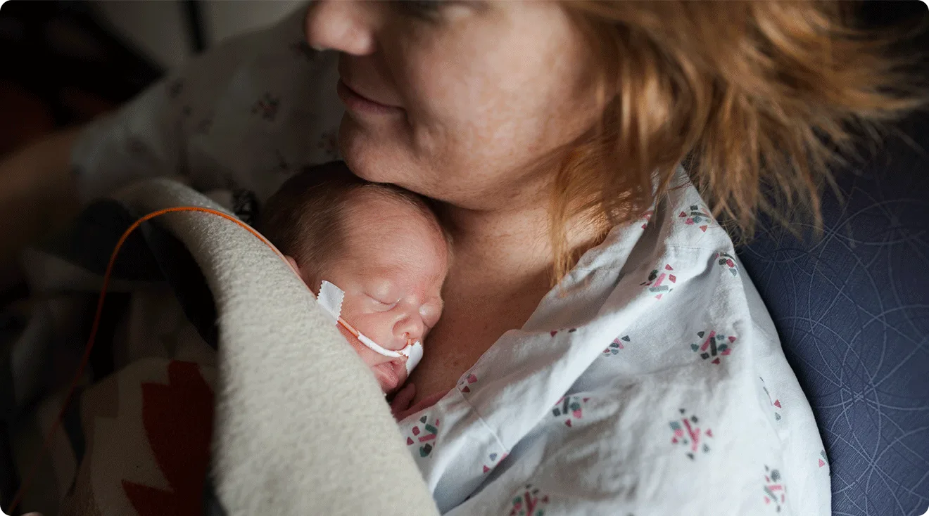 mom holding premature baby in hospital