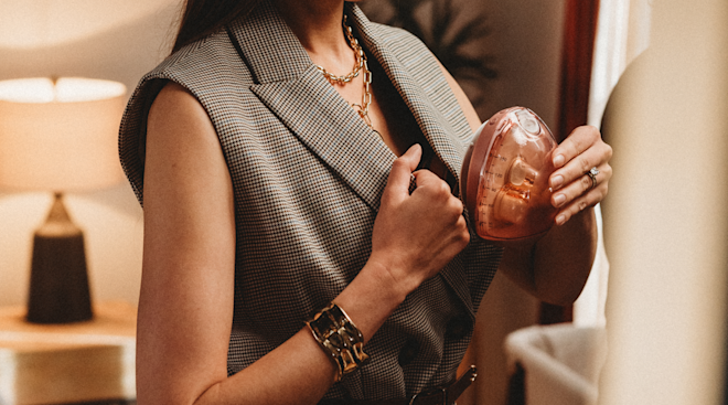 mom in work attire putting wearable breast pump inside shirt