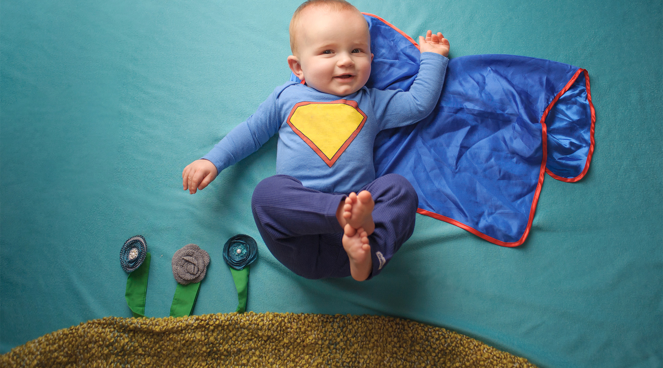 baby dressed up as super hero with blue cape