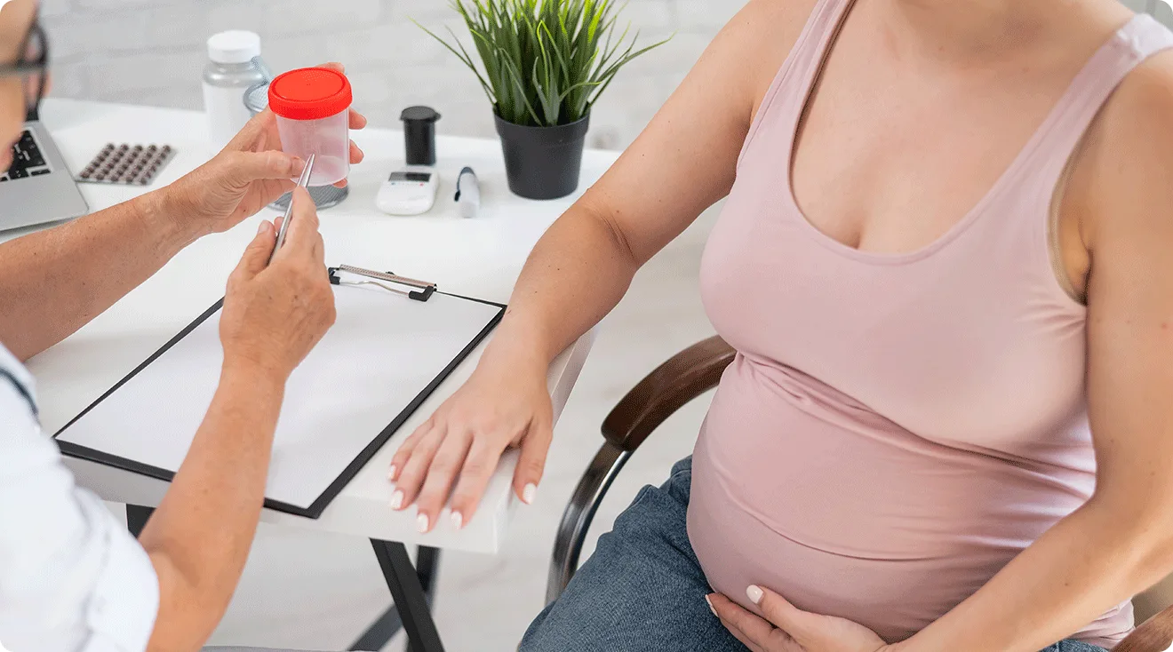 doctor giving pregnant woman urine sample cup