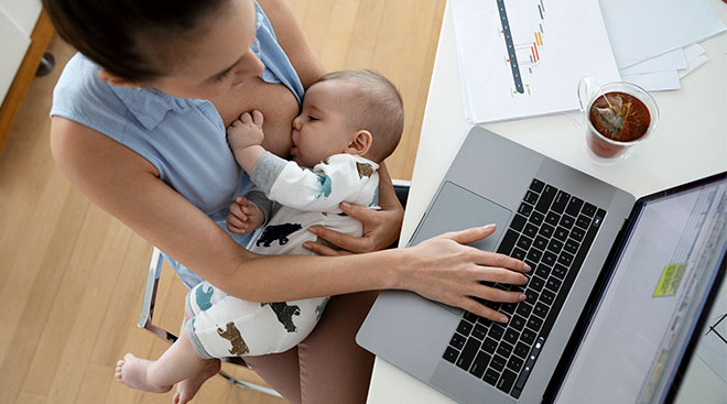 mom working on computer and breastfeeding her baby