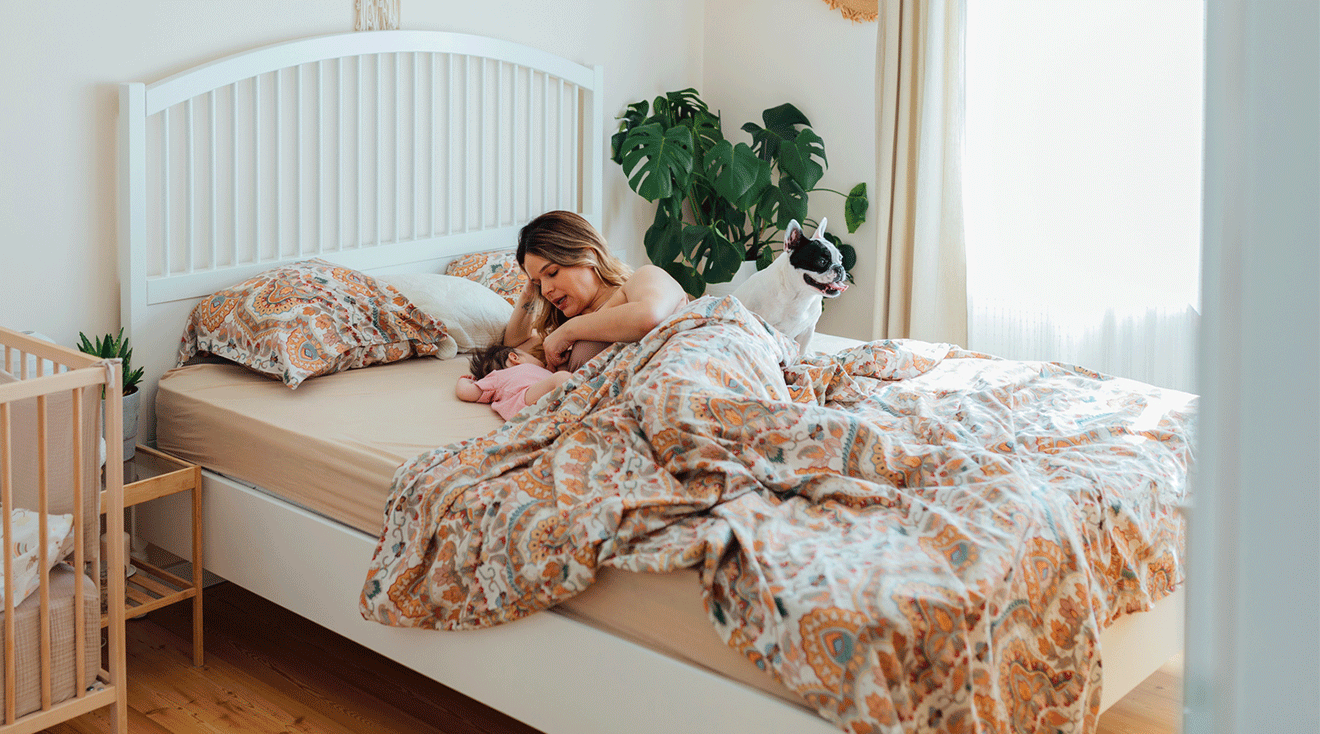 postpartum mother with newborn baby in bed at home