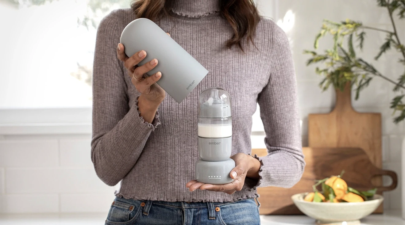 woman holding new ember self warming baby bottle system