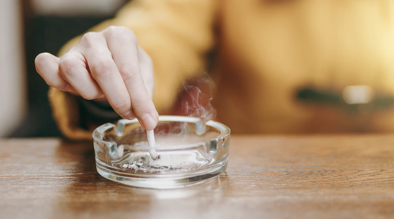 woman putting out a cigarette in ashtray