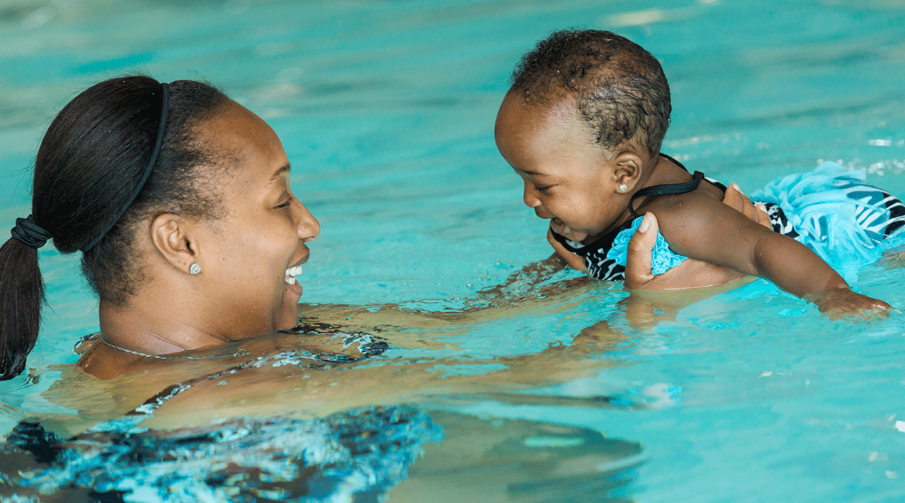 mom teaching baby how to swim in pool