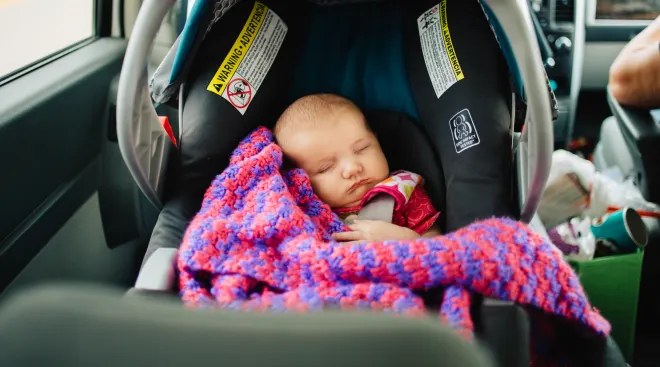 Little baby sleeping in car in forward facing car seat. 
