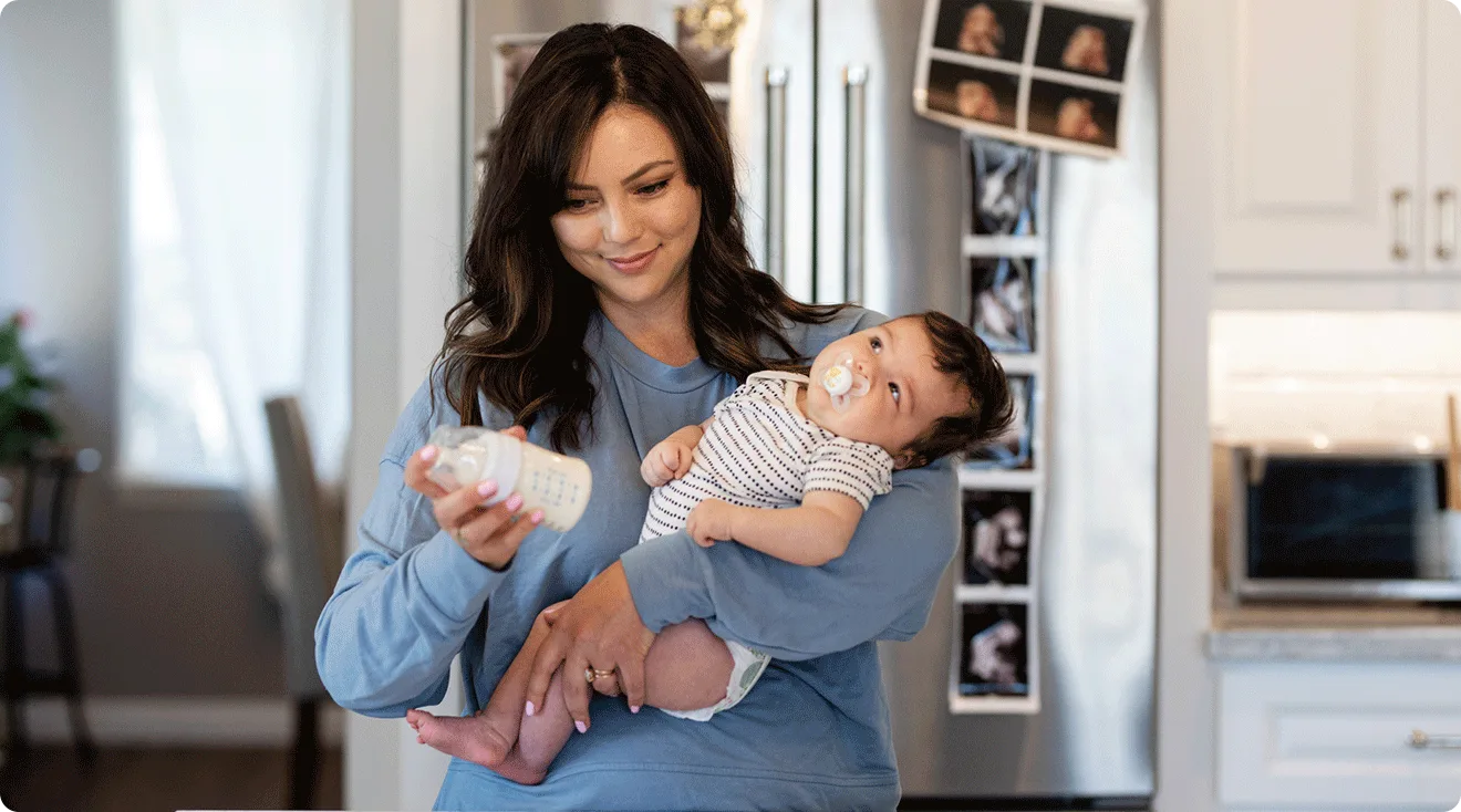 mom making formula bottle for baby at home in kitchen
