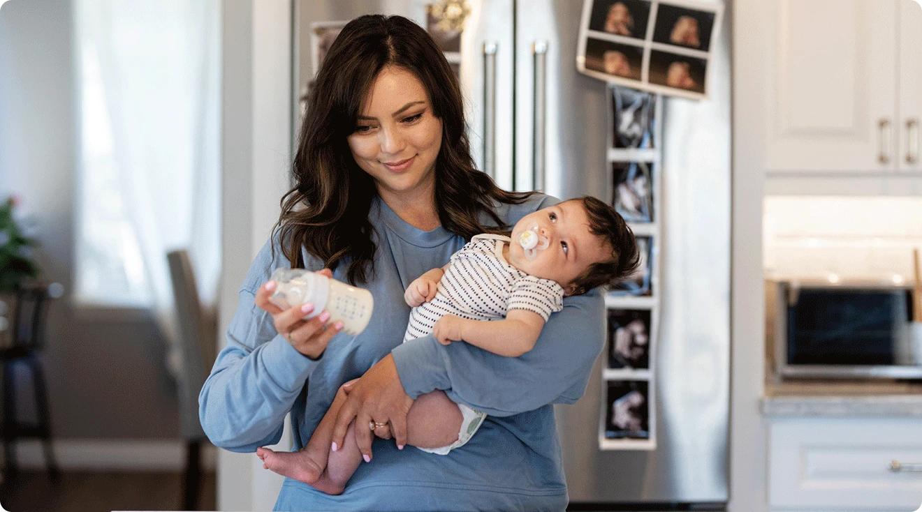 mom making formula bottle for baby at home in kitchen