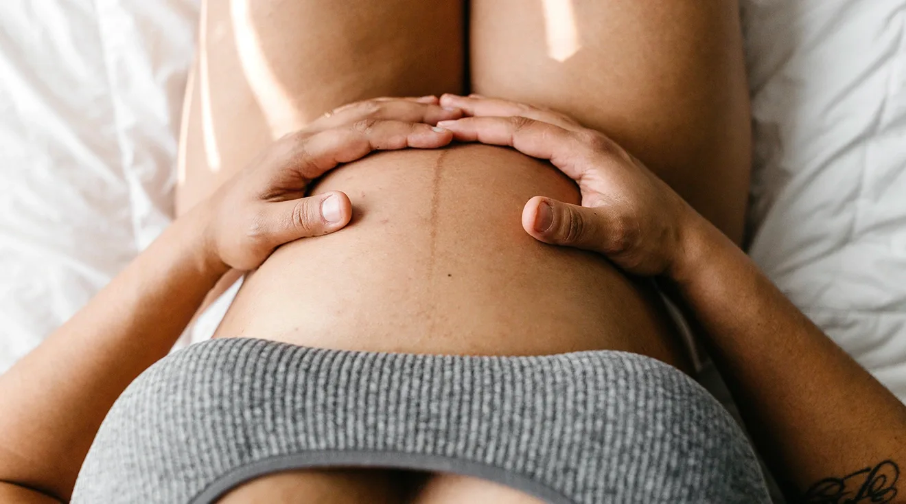 close up of pregnant belly in bed