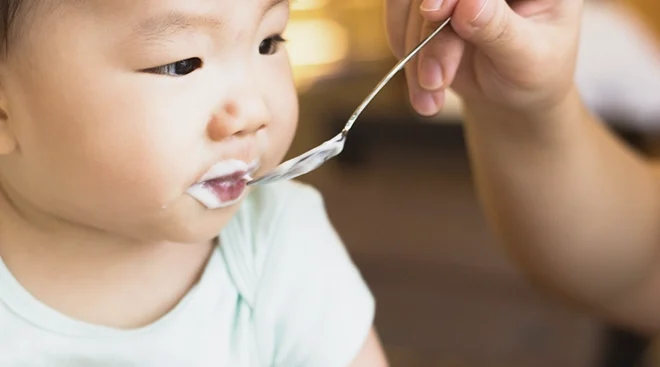 baby being fed yogurt, close up