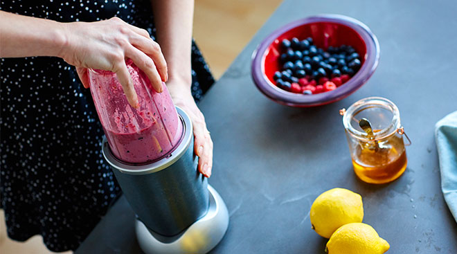 hands using blender to make healthy fruit based baby food
