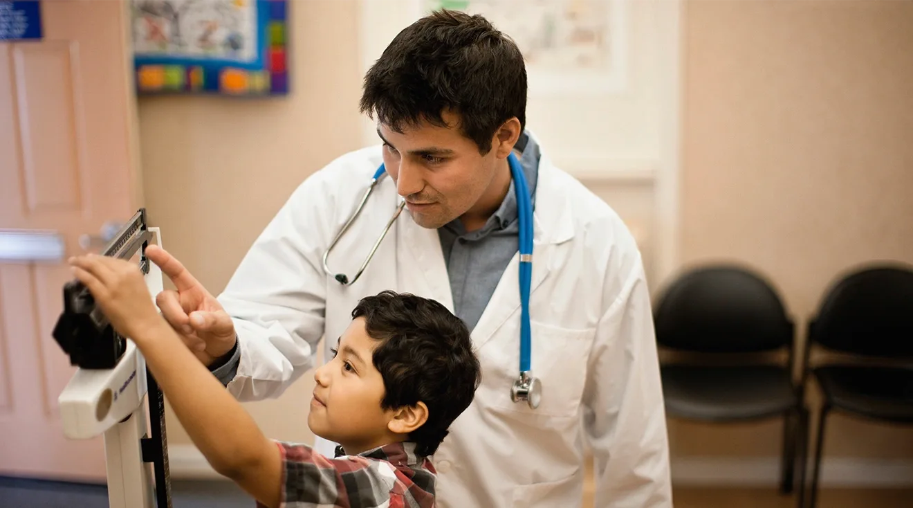 doctor weighing child on scale