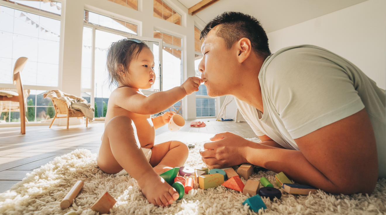 dad playing game with baby on the floor