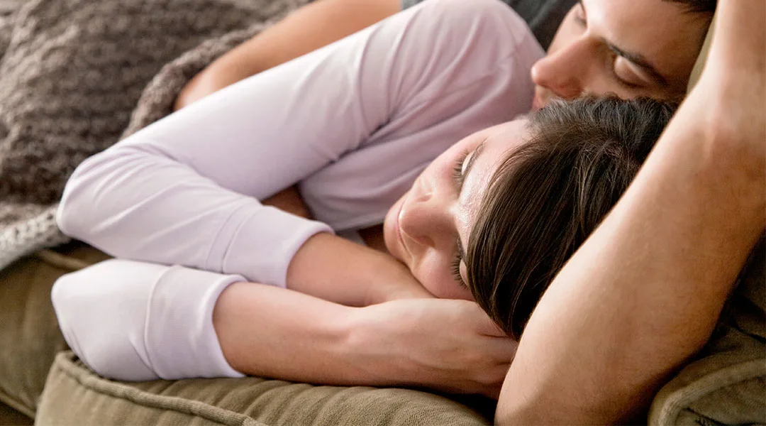 parents nap on couch at newborn shoot