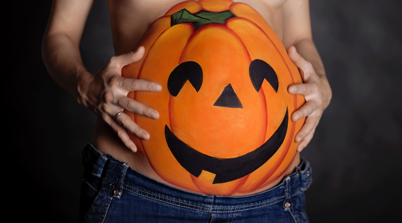 pregnant woman with halloween jack-o-lantern painted on belly