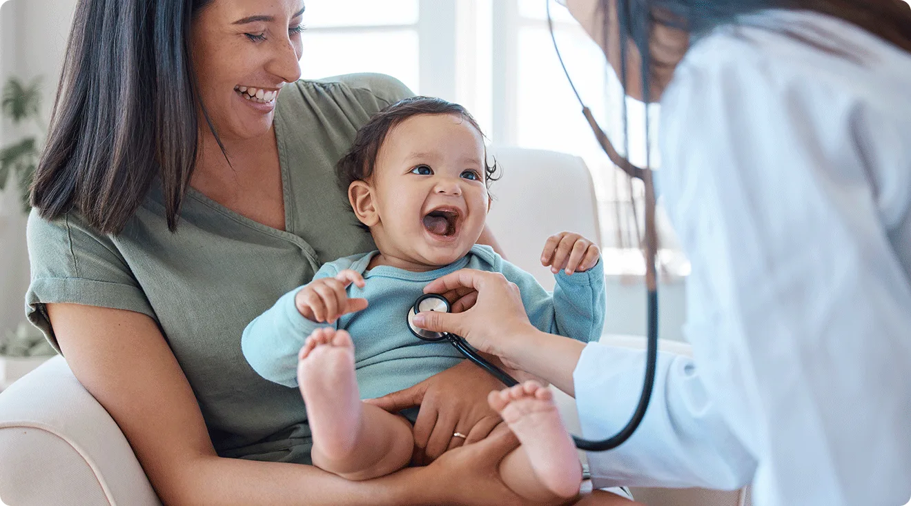 happy healthy baby being checked by pediatrician
