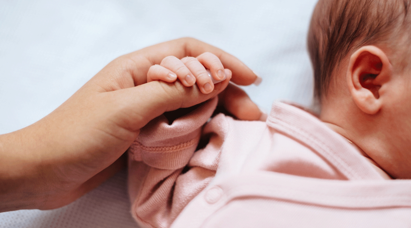 mom holding infant's hand