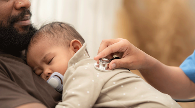 doctor checking infant's lungs with stethoscope