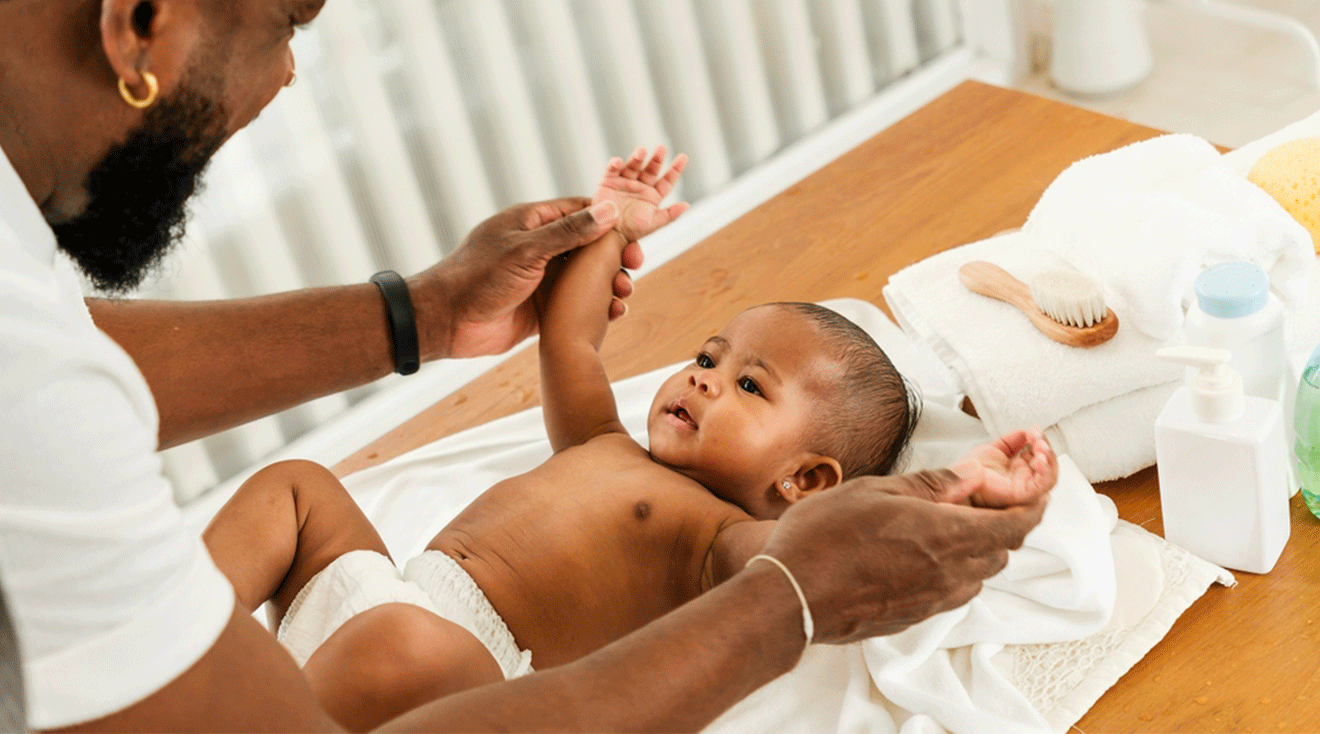 dad changing baby diaper