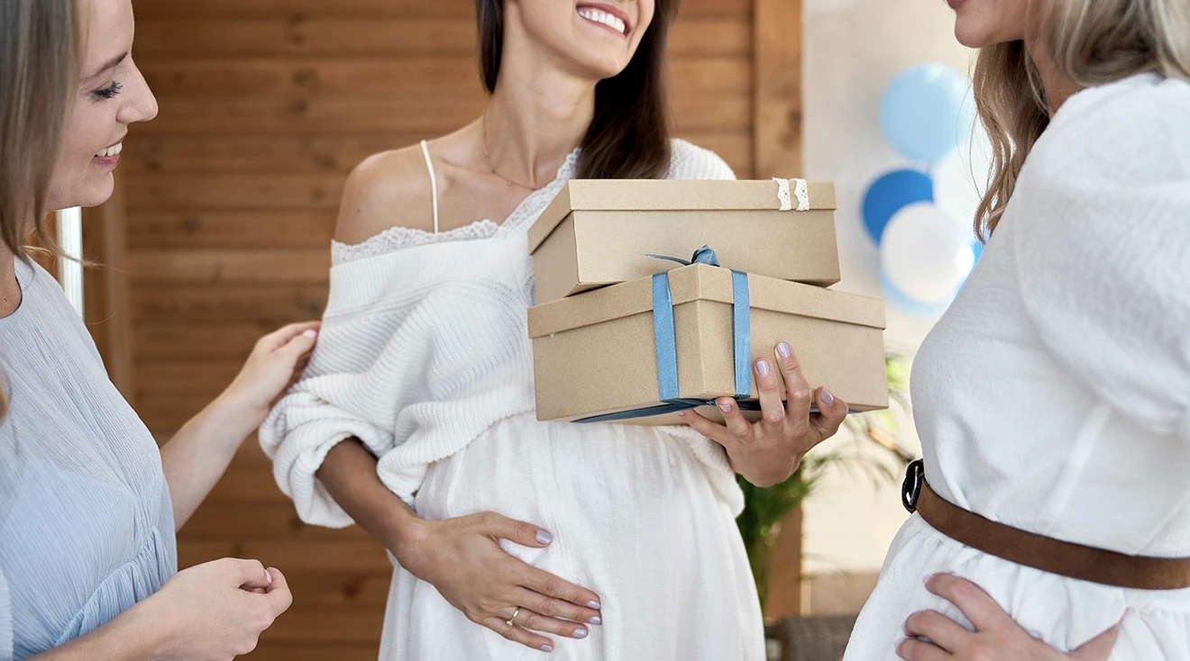 friends giving pregnant woman gifts