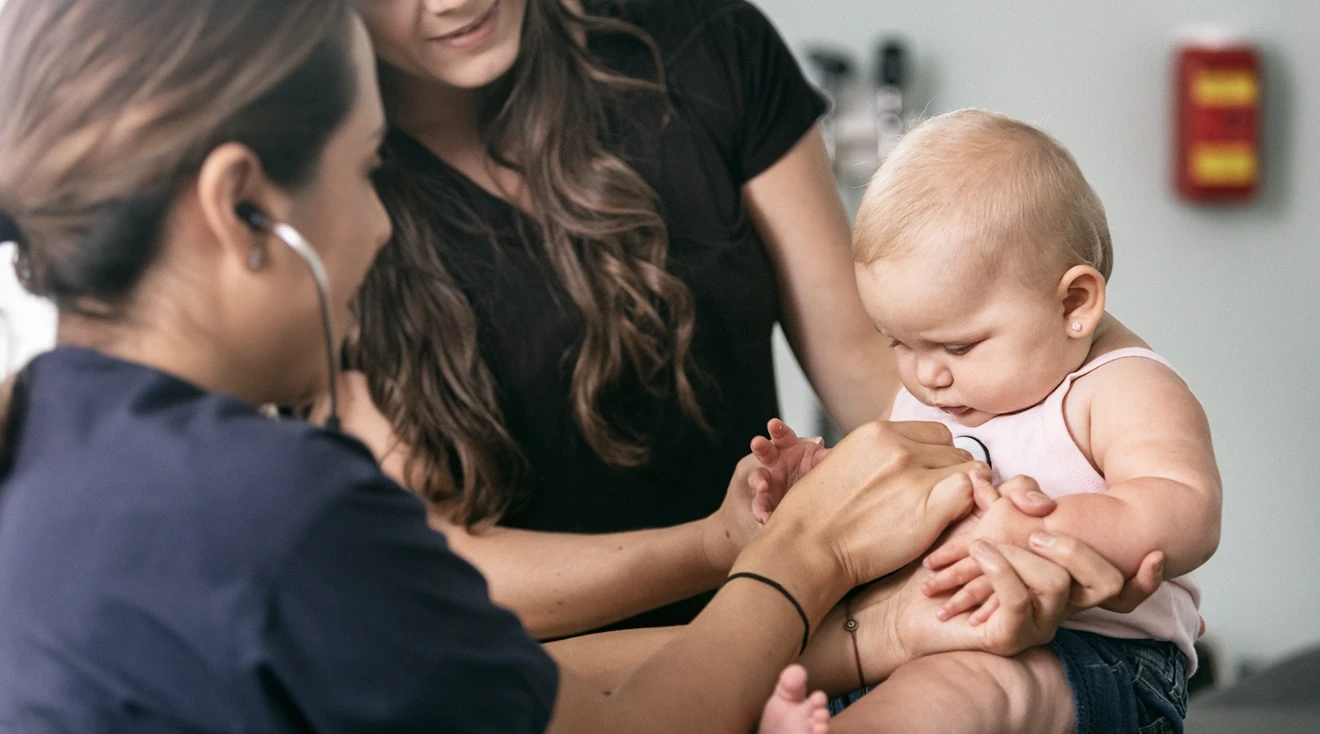 doctor examining one year old baby during 12 month check up