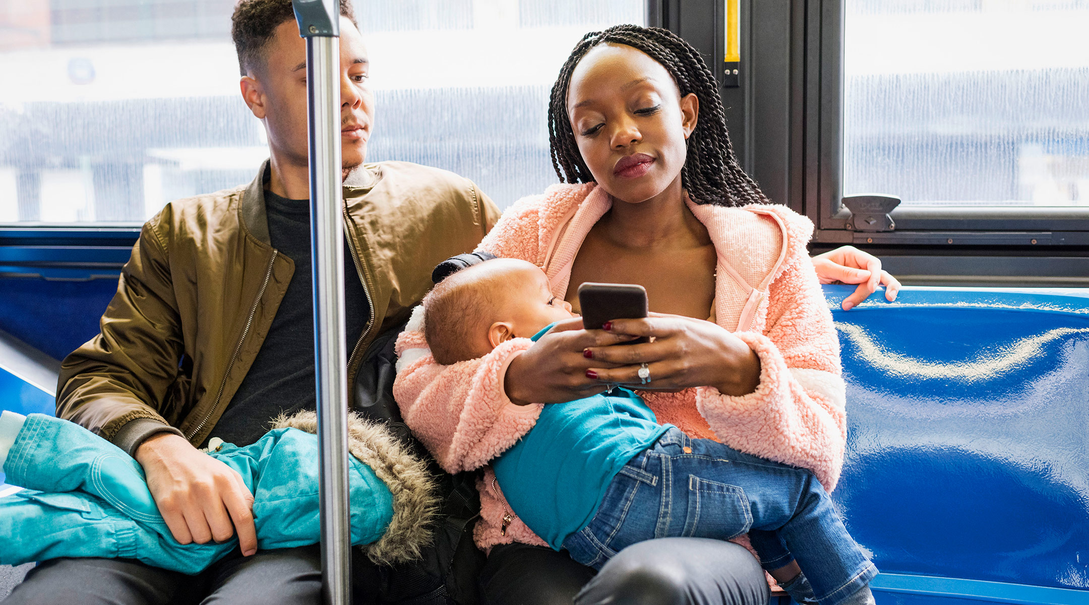 mom breastfeeding her baby in public on the bus next to her partner