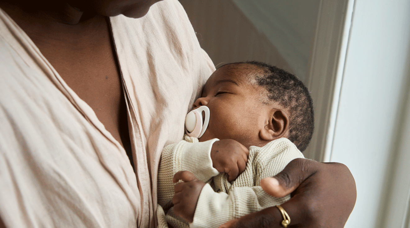 mom holding sleeping baby