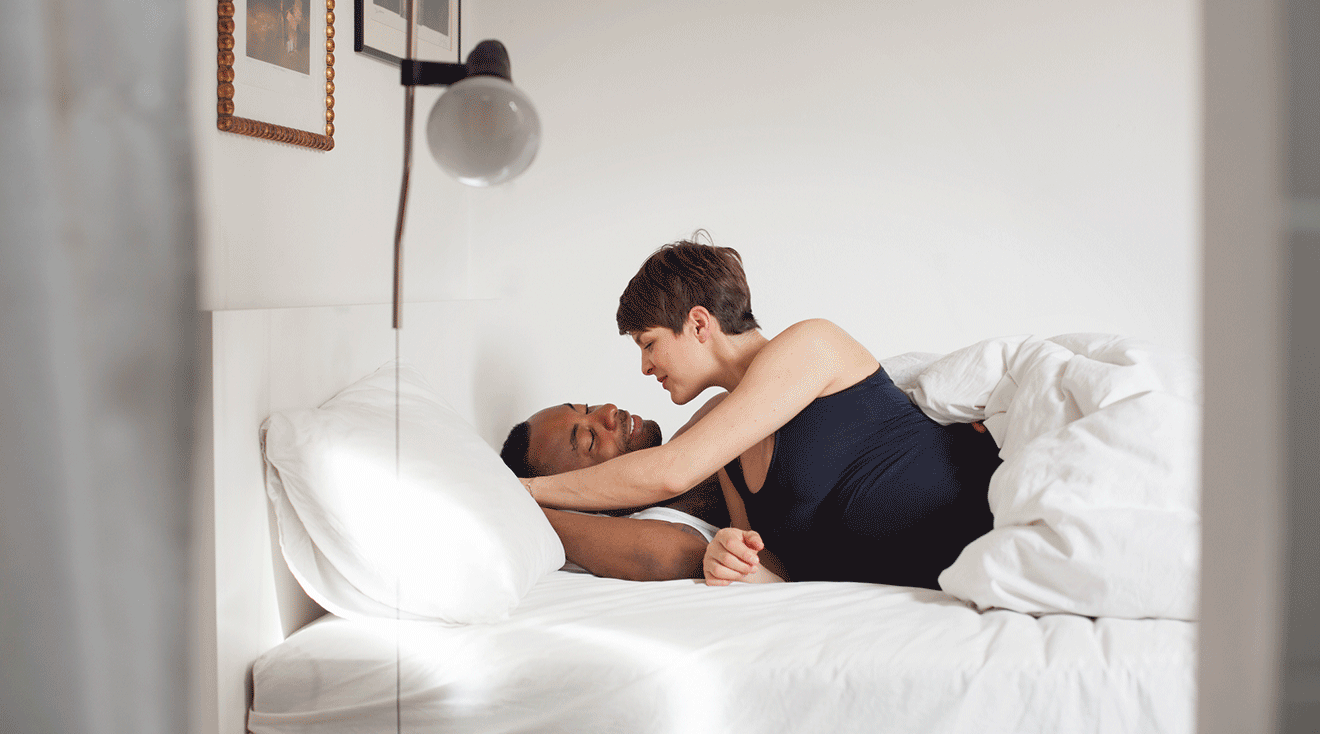 pregnant couple embracing in bed