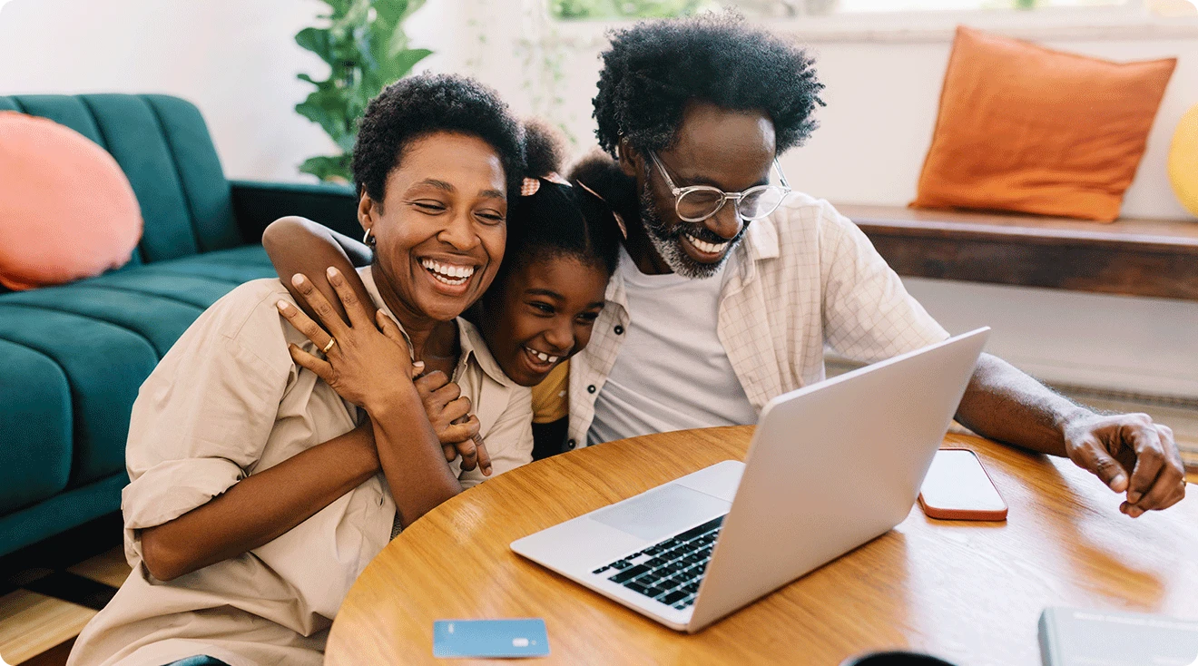 mom and dad shopping on laptop with daughter at home