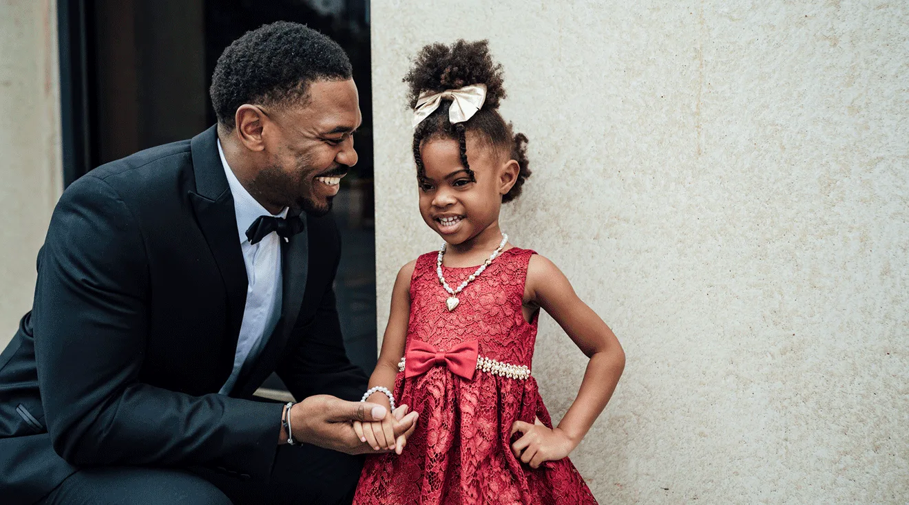 father and daughter dressed in formal clothes smiling