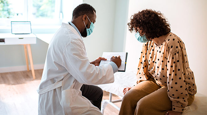 Woman talking to her doctor at the doctor's office. 