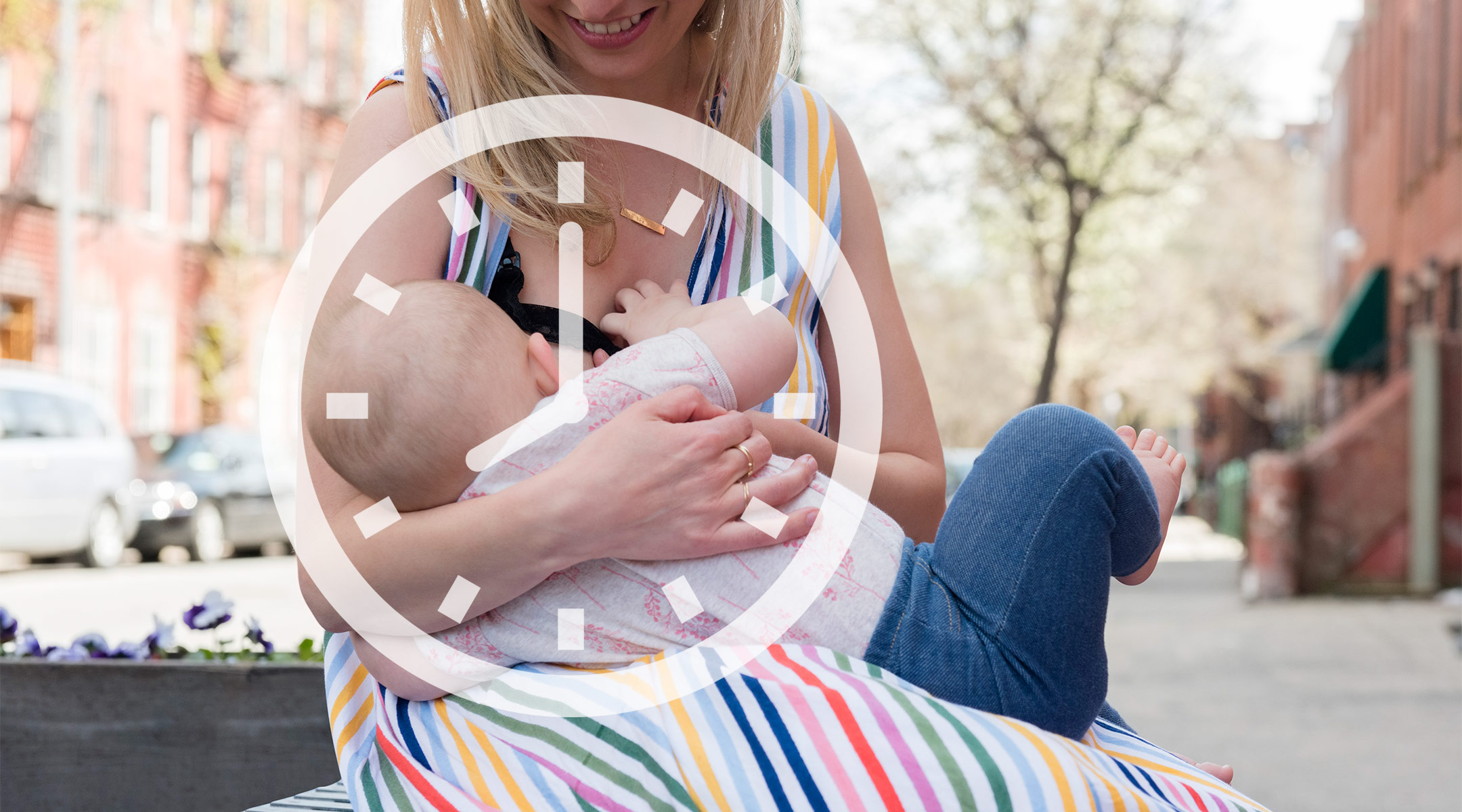 mom breastfeeding her baby outside in a neighborhood