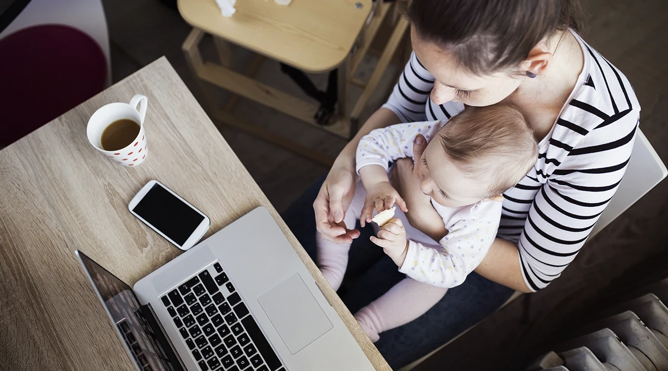 mother working from home with baby on lap