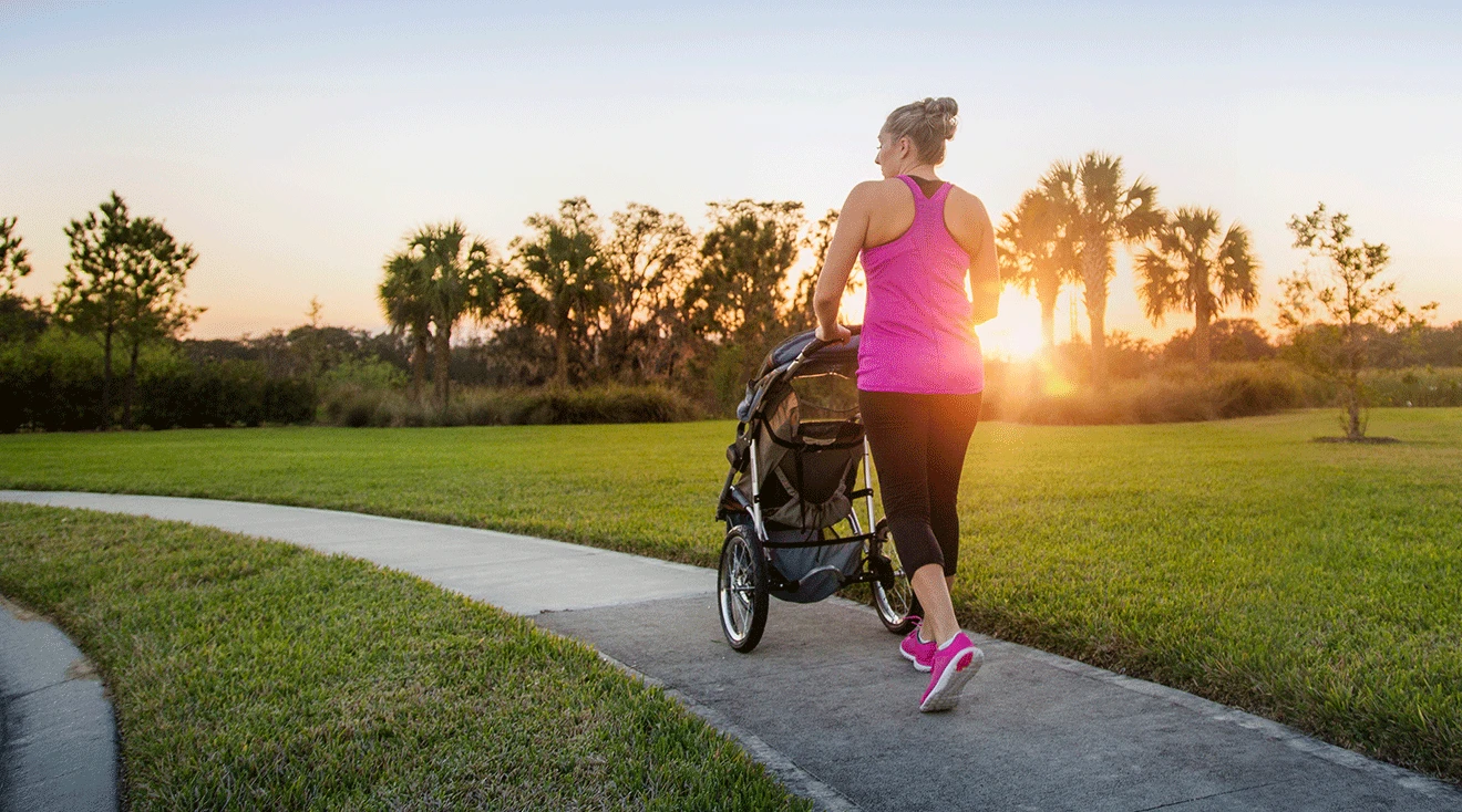 mom jogging with baby stroller in neighborhood outside