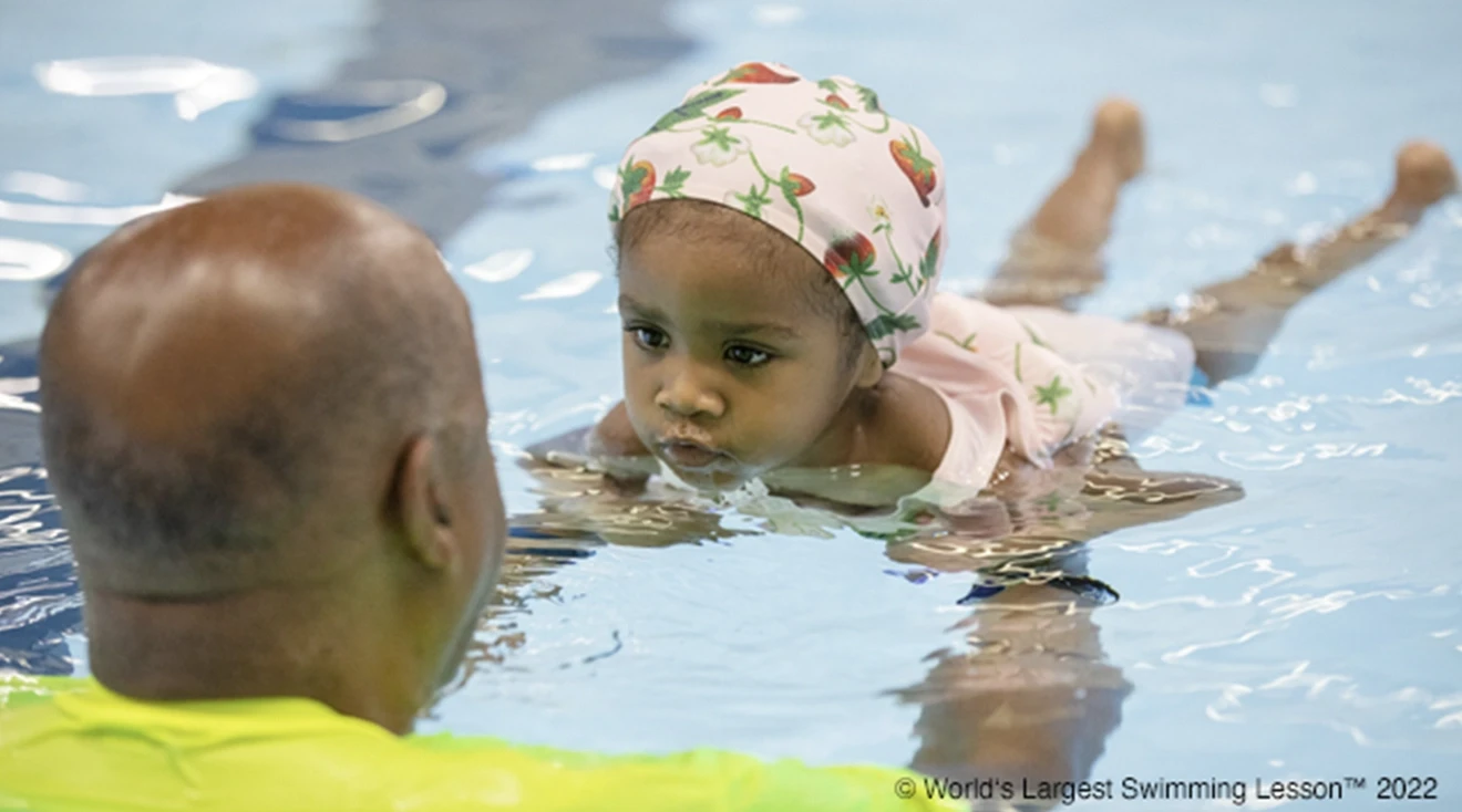 The World's Largest Swimming Lesson 2023 little girl being taught how to swim in pool