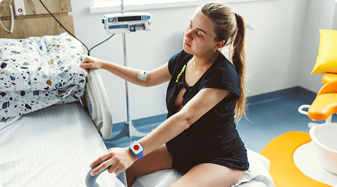 pregnant woman in labor sitting on exercise ball in hospital room