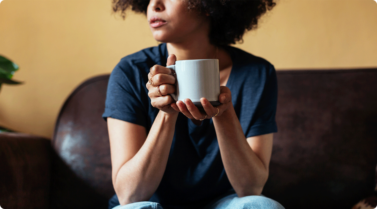 woman drinking at cup of tea at home on the couch